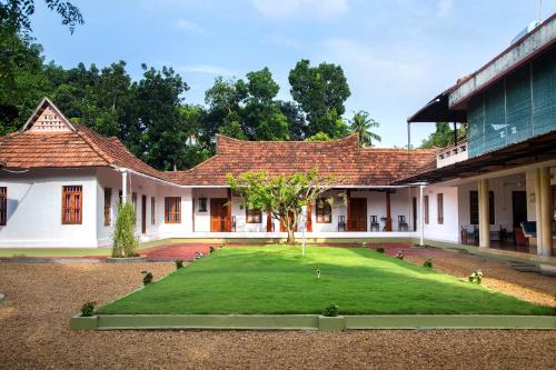 a courtyard of a house with a grass yard at Akkara Homestay & Ayurveda in Kottayam