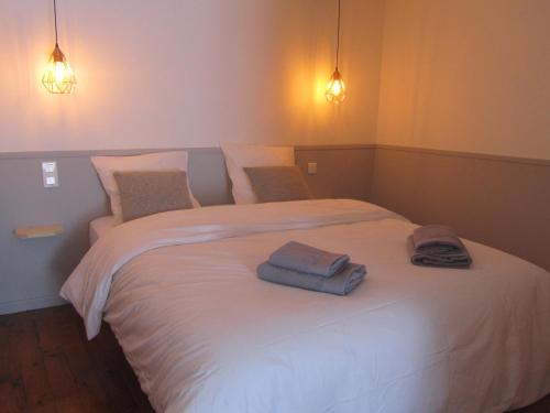1 dormitorio con 1 cama blanca y 2 toallas en Hôtel Restaurant le Saint Marc, en Aups