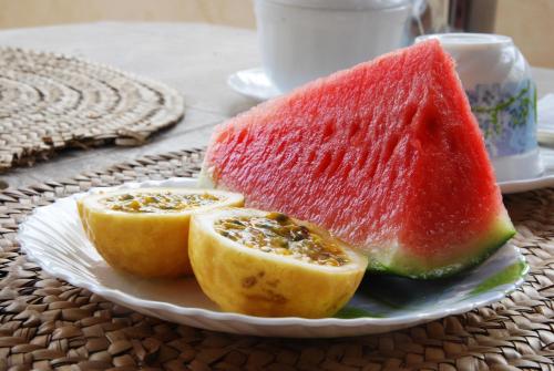 a plate with two slices of fruit on a table at JamboHouse Lamu in Lamu