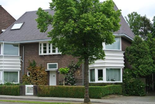 a house with a tree in front of it at Aldenhof Appartementen in Maastricht