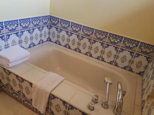 a bathroom with a bath tub with a towel at Sophia Suites Residence Hotel in Cebu City