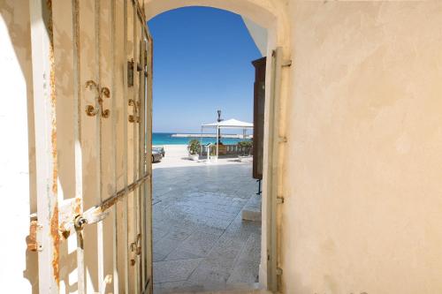 an open door with a view of the beach at Appartamento Al Bastione by BarbarHouse in Otranto