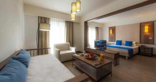 アキアーラにあるLIV Hotel by Bellazureのベッドとリビングルームが備わるホテルルームです。