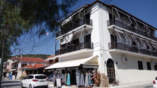 a white building with a store in front of it at Athina-Milina in Milína