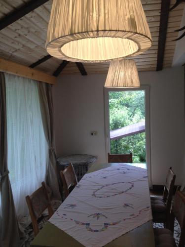 a dining room with a table and a chandelier at Fisherman's Cottage in Cacica