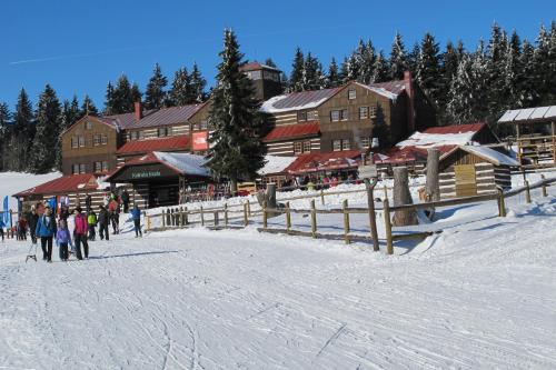 a group of people walking in the snow in front of a ski lodge at Horský dům Veronika in Cerny Dul