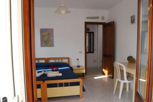 a bedroom with a bed and a table in a room at Baia Unci in Canneto