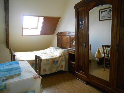 a small bedroom with a bed and a dresser at Chambres Kercymado in Mûr-de-Bretagne