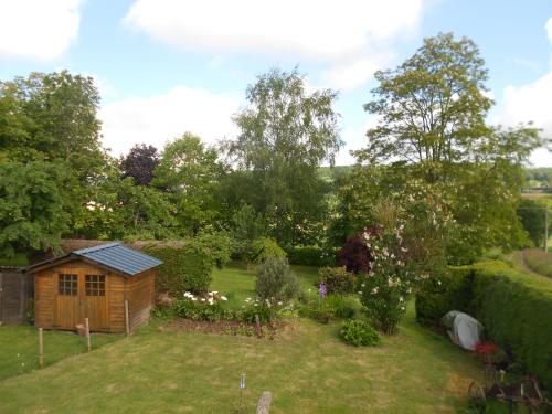 a garden with a wooden shed in the middle of a yard at Chambres Kercymado in Mûr-de-Bretagne