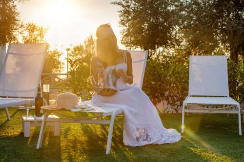 a woman sitting in a chair in the grass at MelRose Relais in Massa Lubrense