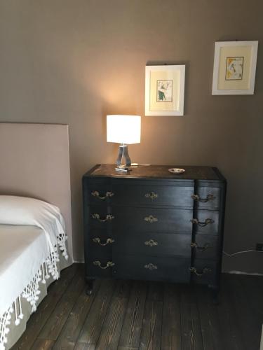 a bedroom with a dresser with a lamp on it at B&B Santapau Charme Living in Licodia Eubea