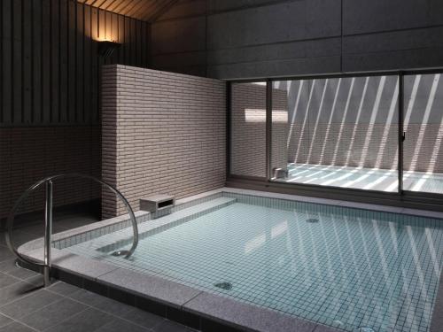 a large swimming pool with a shower in a building at Osaka Academia in Osaka