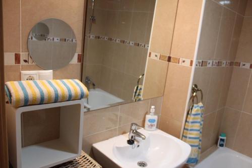 a bathroom with a sink and a mirror and a tub at Residencial Algaida in Oropesa del Mar