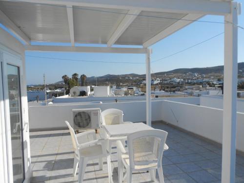 a white table and chairs on a balcony at Nicolas Antiparos in Antiparos Town