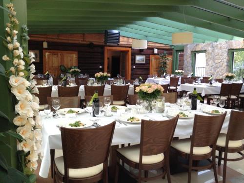 a dining room with white tables and chairs with flowers at Hotel Modrzewiówka in Lanckorona