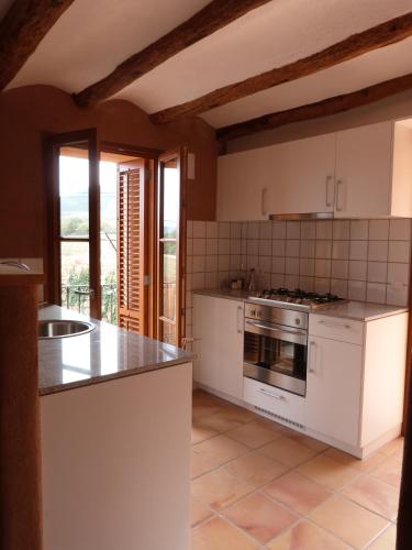 a kitchen with white cabinets and a stove top oven at Can Gramunt in La Torre de Claramunt