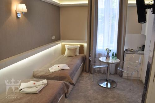 pokój z dwoma łóżkami, stołem i oknem w obiekcie Apartamenty Podwale w Krakowie