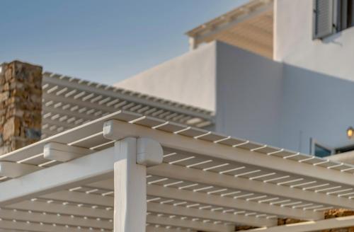 a white pergola on the side of a building at Elia Mykonos Resort in Elia Beach