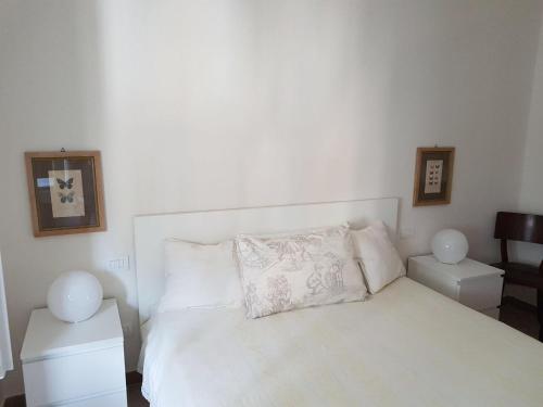 ラ・スペツィアにあるSky Apartmentのベッドルーム1室(白いベッド1台、ナイトスタンド2台付)