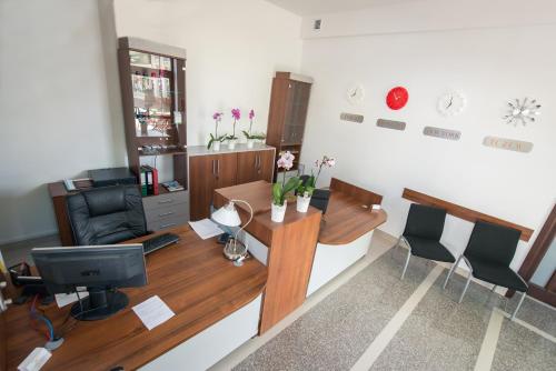 an office with a desk with a television and chairs at First Hotel in Tczew