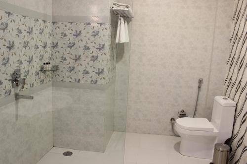 a bathroom with a toilet and a shower at Regenta Central Mewargarh, Near Biological park in Udaipur