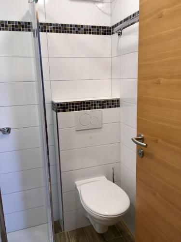 a small bathroom with a toilet and a door at Haus Lisa in Fuschl am See
