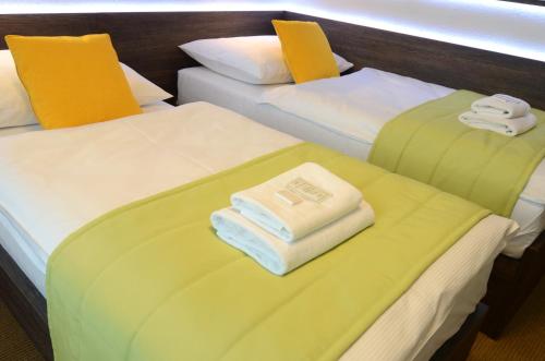 two beds in a room with towels on them at Hotel Uno in Ústí nad Orlicí