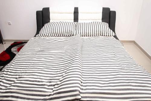 a bed with a black and white blanket on it at Motel Medium in Bihać