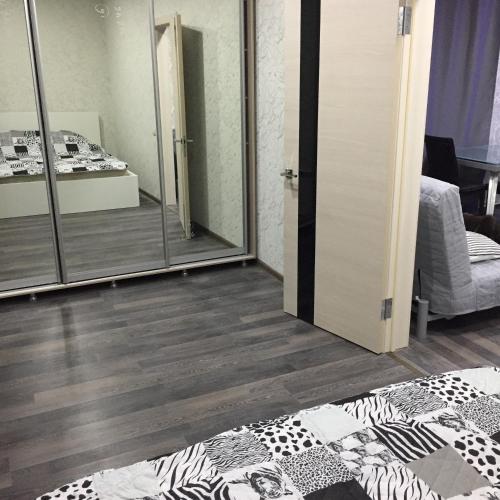 シャフティにあるApartment on ulitsa Mayakovskogo 94の鏡とベッド付きの部屋、ベッドサイド付きの部屋