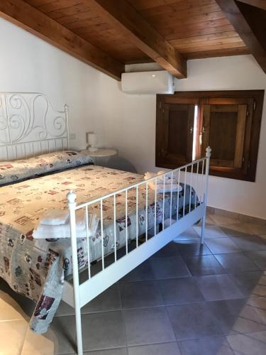 sypialnia z białym łóżkiem i drewnianym sufitem w obiekcie Casa Vacanze Primula palinuri w mieście Futani