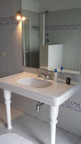 a bathroom with a white sink and a mirror at Appartamenti in Villa incanto dei trabocchi Un gioiello esclusivo tra mare e natura in Treglio