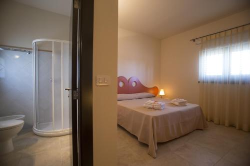 a bedroom with a bed and a bathroom with a shower at Villa De Pietro in Cursi