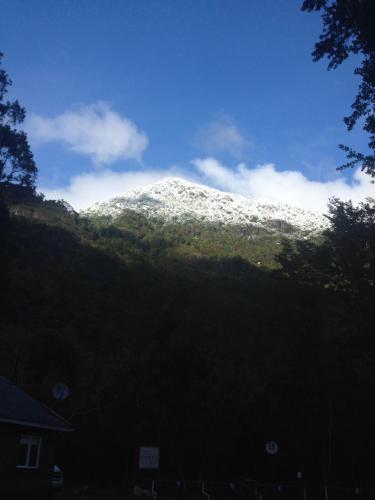 a snow covered mountain in front of a house at Cuyinco Domos in Riñinahue