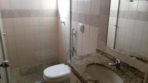 y baño con lavabo, aseo y espejo. en Vitoria das Thermas - 3 Quartos - Achei Ferias, en Caldas Novas