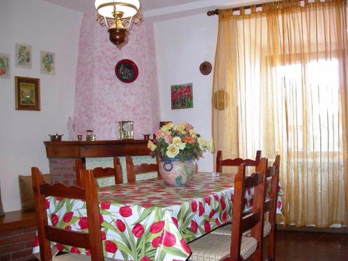 einen Esstisch mit einer Blumenvase darauf in der Unterkunft Casa del Ciliegio in Radicofani