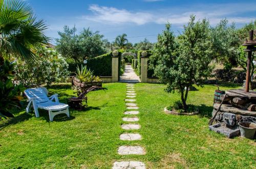 a garden with a stone path in the grass at B&B Etna Ranch in Piedimonte Etneo
