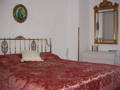 a bedroom with a bed with a red blanket and a mirror at Casa del Ciliegio in Radicofani