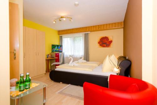 ユーデンブルクにある1a Hotel Steinerのベッドルーム1室(ベッド1台、赤い椅子付)