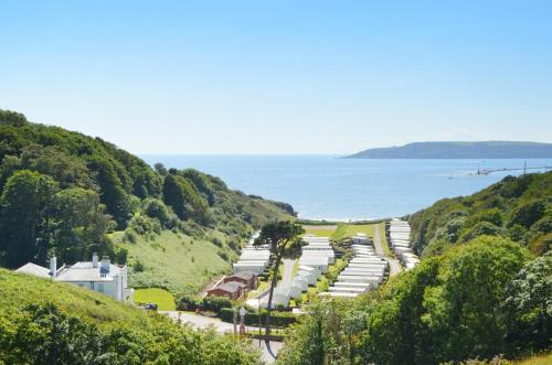 a road on a hill next to the ocean at Bovisand Lodge Holiday Park, Beachside Location & Indoor Heated Pool in Plymouth