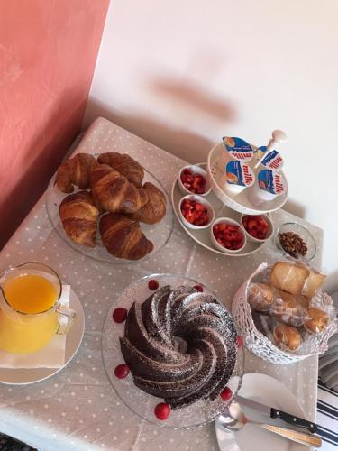 uma mesa coberta com pratos de pão e pastelaria em Bed and Breakfast La Terra dei Mari em Pachino