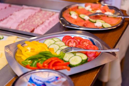 a tray of vegetables on a table with plates of food at 1a Hotel Steiner in Judenburg
