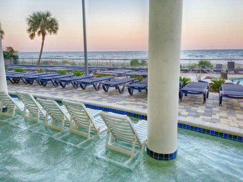 a swimming pool with chairs and the beach at New Ocean Front Corner Unit in Myrtle Beach