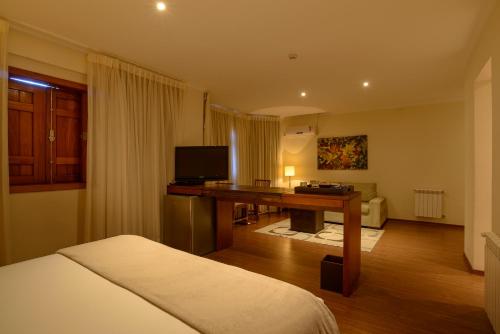 a hotel room with a desk and a bed at Hotel Le Renard - Campos do Jordao in Campos do Jordão