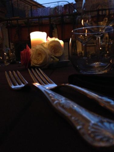 a table with a fork and a candle and a napkin at B&B Santapau Charme Living in Licodia Eubea