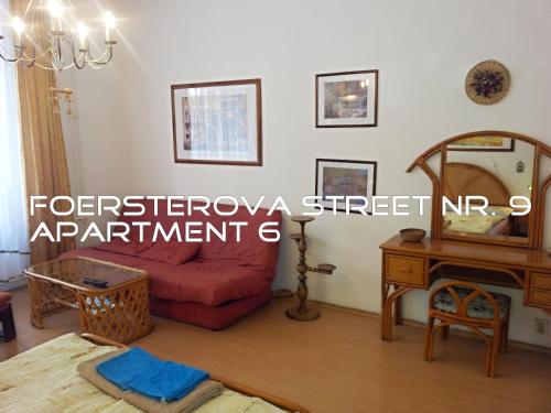 a living room with a red couch and a table at Holiday Apartments in Karlovy Vary