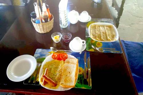 a table with a sandwich and a plate of food at Bahari Dhow Beach Villas in Diani Beach
