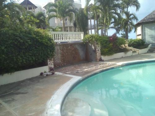 a swimming pool in front of a house at Elegant Condo Awesome View in Ocho Rios