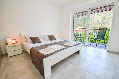 um quarto com uma cama grande e uma janela grande em Bay View Apartments em Kotor