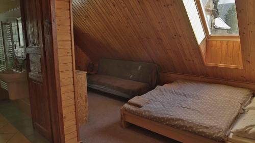 a small bedroom with a bed and a window at Penzion Ostruznik in Ostružná