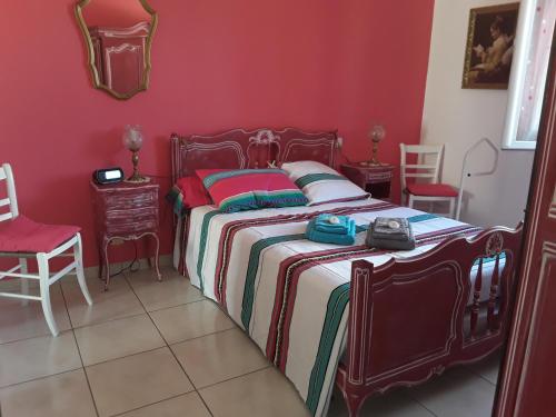 1 dormitorio con 1 cama con paredes rojas y sillas rojas en Chez Yannick et Isabelle, en Saint-Nazaire